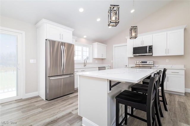 3604 Eldersville Rd, Colliers, WV 26035 - kitchen featuring vaulted ceiling, light wood-type flooring, a kitchen island, appliances with stainless steel finishes, and white cabinetry