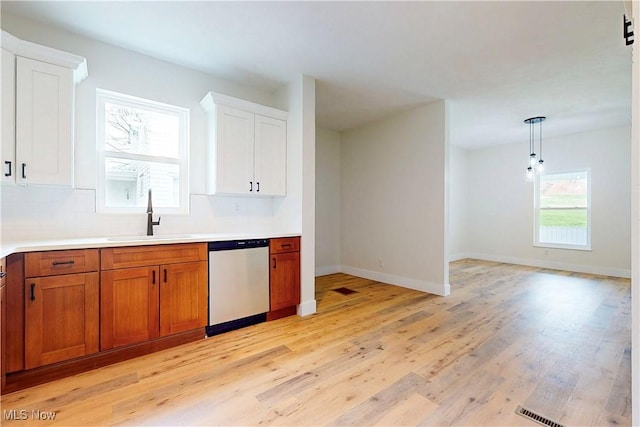 kitchen with dishwasher, a sink, light wood-style floors, brown cabinetry, and white cabinetry