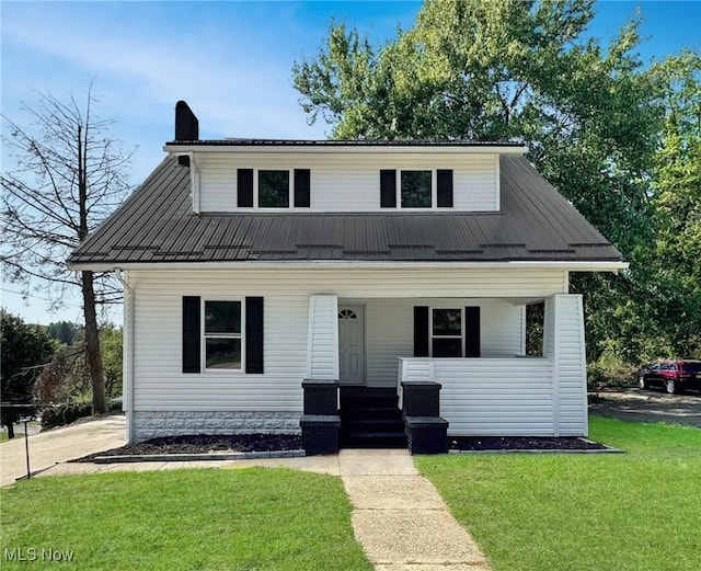 bungalow featuring a porch, a front lawn, metal roof, and a chimney