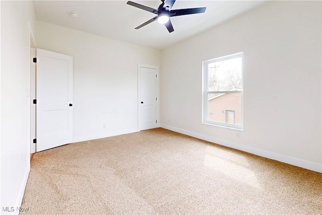 unfurnished bedroom featuring a ceiling fan, baseboards, and carpet