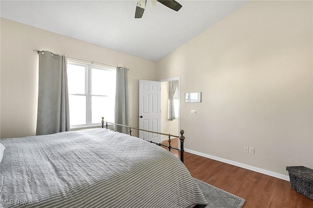 bedroom featuring baseboards, vaulted ceiling, wood finished floors, and a ceiling fan