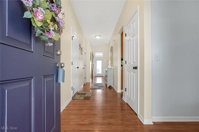 corridor featuring wood finished floors and baseboards