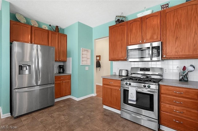 kitchen featuring backsplash, baseboards, and stainless steel appliances