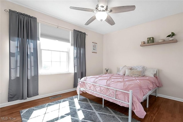 bedroom featuring ceiling fan, baseboards, wood finished floors, and visible vents