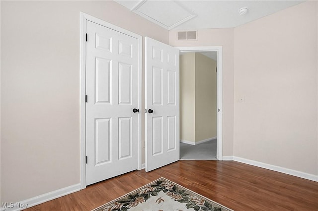 unfurnished bedroom with baseboards, wood finished floors, and visible vents