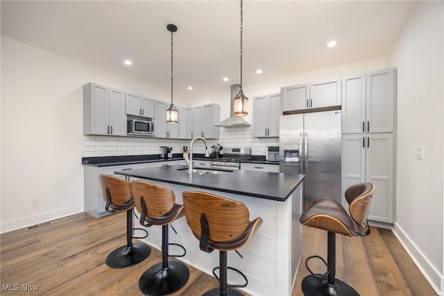 1804 28th St, Vienna, WV 26105 - kitchen with dark countertops, wood finished floors, a sink, wall chimney exhaust hood, and appliances with stainless steel finishes