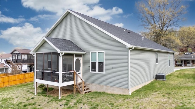 1804 28th St, Vienna, WV 26105 - rear view of property featuring central AC unit, a lawn, fence, a sunroom, and roof with shingles
