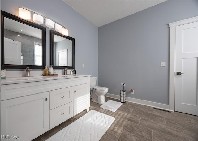 1804 28th St, Vienna, WV 26105 - full bath featuring double vanity, toilet, baseboards, and a sink