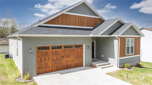 1804 28th St, Vienna, WV 26105 - view of front of home featuring a shingled roof, driveway, central AC, and a garage