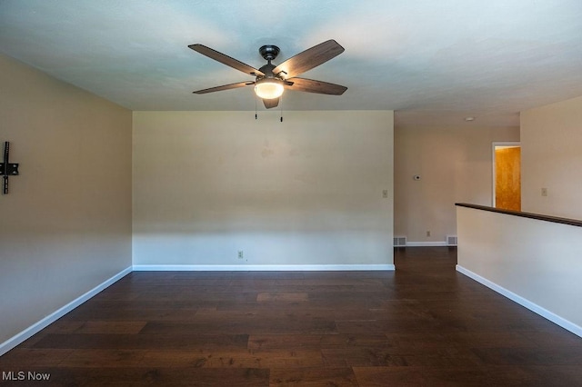 unfurnished room featuring wood finished floors, visible vents, baseboards, and ceiling fan