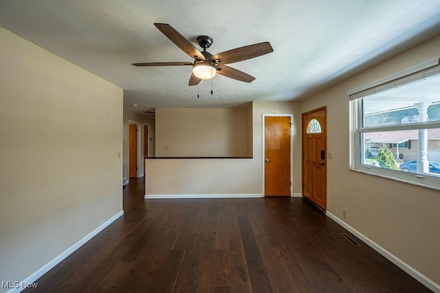 interior space featuring baseboards, dark wood-type flooring, and ceiling fan