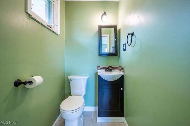 bathroom featuring baseboards, tile patterned flooring, vanity, and toilet