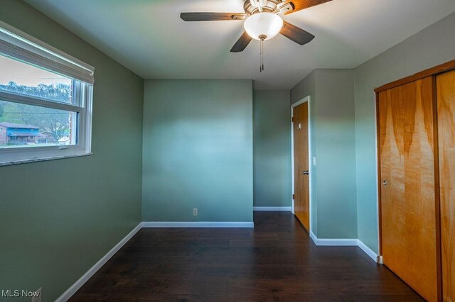 unfurnished room with baseboards, a ceiling fan, and wood finished floors