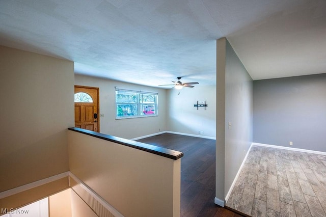 hallway with baseboards and wood finished floors