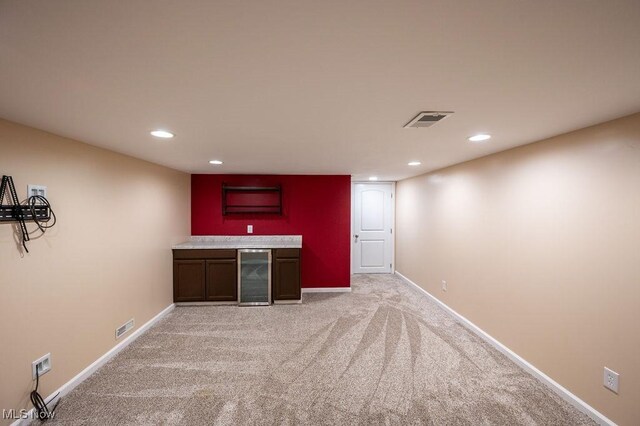 bar with indoor wet bar, visible vents, beverage cooler, and recessed lighting