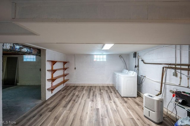 below grade area featuring plenty of natural light, light wood-style flooring, and independent washer and dryer