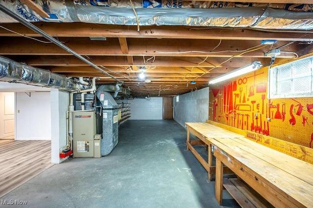 basement with a workshop area and heating unit
