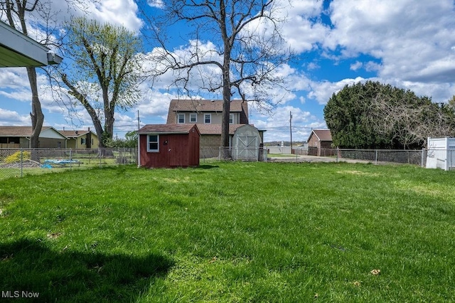 view of yard featuring a fenced backyard, an outbuilding, and a shed