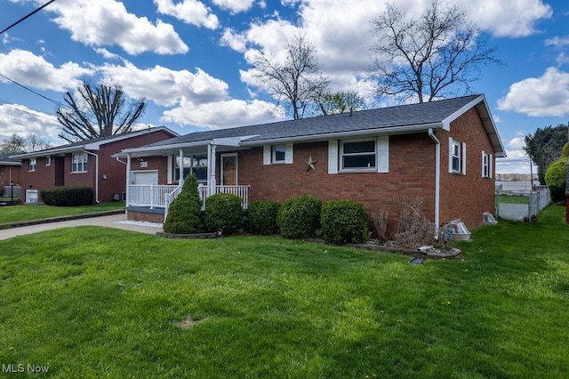 view of front of home with brick siding, a porch, and a front yard
