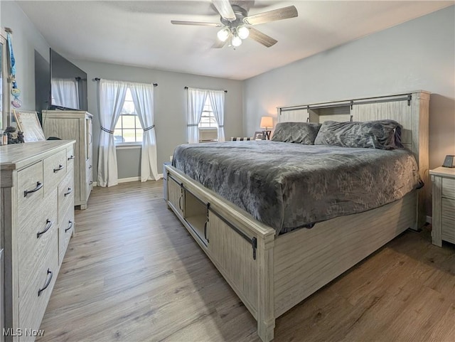 bedroom featuring a ceiling fan, baseboards, and light wood-style floors