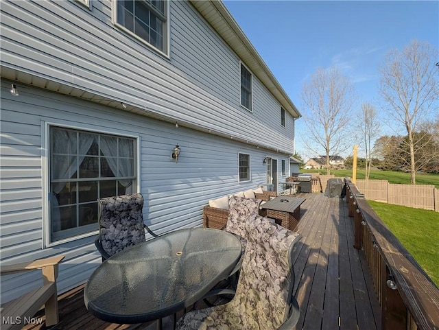 deck with fence, outdoor dining area, and a yard