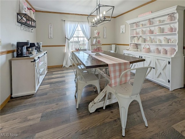 dining space with ornamental molding, a notable chandelier, baseboards, and dark wood-type flooring