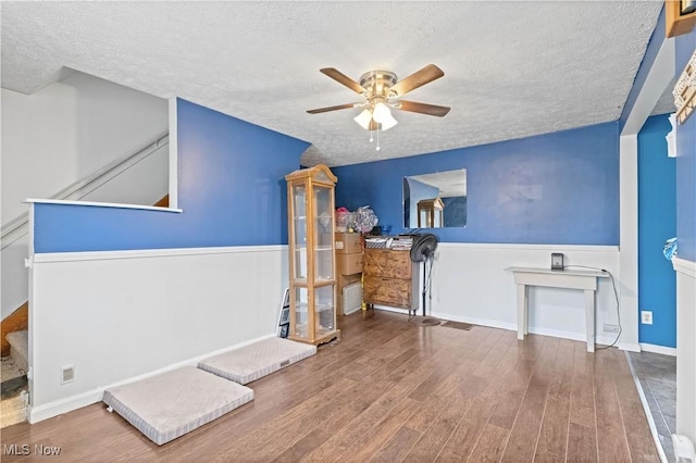 1611 Township Road 1610, Ashland, OH 44805 - living area featuring ceiling fan, wood finished floors, a textured ceiling, and a wainscoted wall