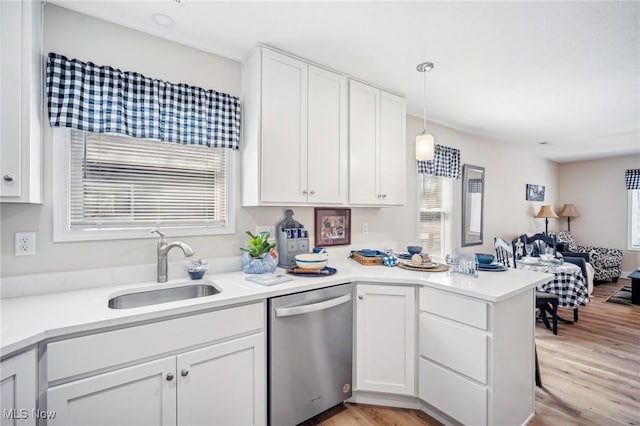 502 Fairlawn Ave, Painesville, OH 44077 - kitchen with stainless steel dishwasher, a peninsula, white cabinets, light countertops, and a sink