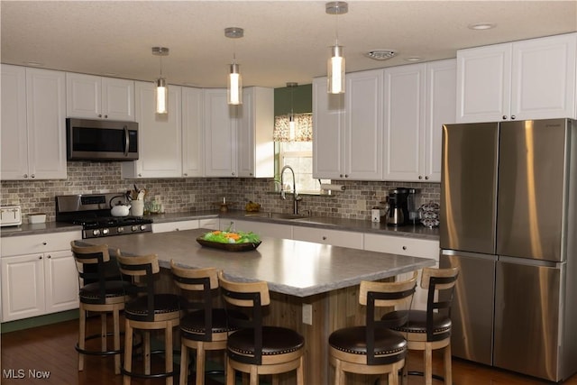 25900 Township Road 26, Coshocton, OH 43812 - kitchen featuring backsplash, dark countertops, a sink, appliances with stainless steel finishes, and white cabinetry