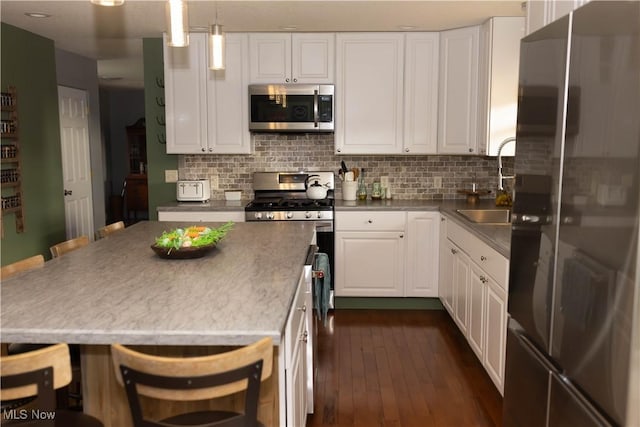 25900 Township Road 26, Coshocton, OH 43812 - kitchen featuring white cabinets, stainless steel appliances, a sink, dark wood-style flooring, and tasteful backsplash