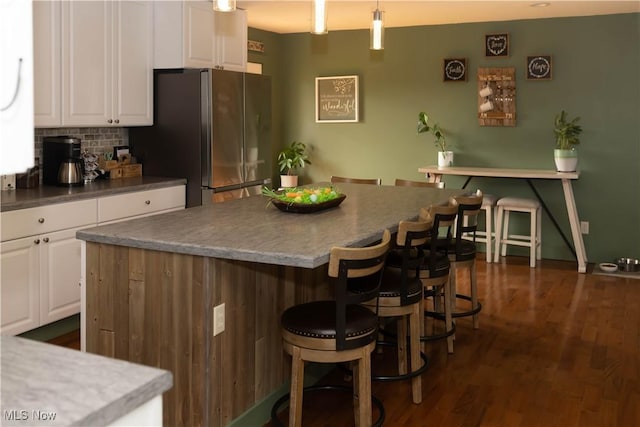 25900 Township Road 26, Coshocton, OH 43812 - kitchen featuring a kitchen breakfast bar, freestanding refrigerator, white cabinetry, and tasteful backsplash