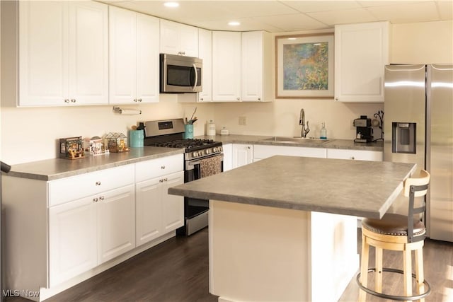 25900 Township Road 26, Coshocton, OH 43812 - kitchen with a sink, a breakfast bar, stainless steel appliances, white cabinets, and dark wood-type flooring