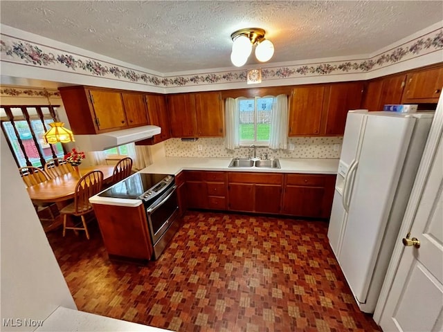kitchen with electric range, a sink, white refrigerator with ice dispenser, and light countertops