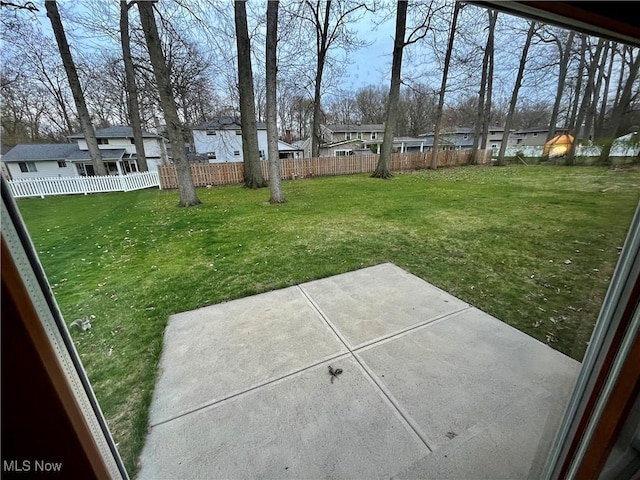 view of yard with a residential view, a fenced backyard, and a patio
