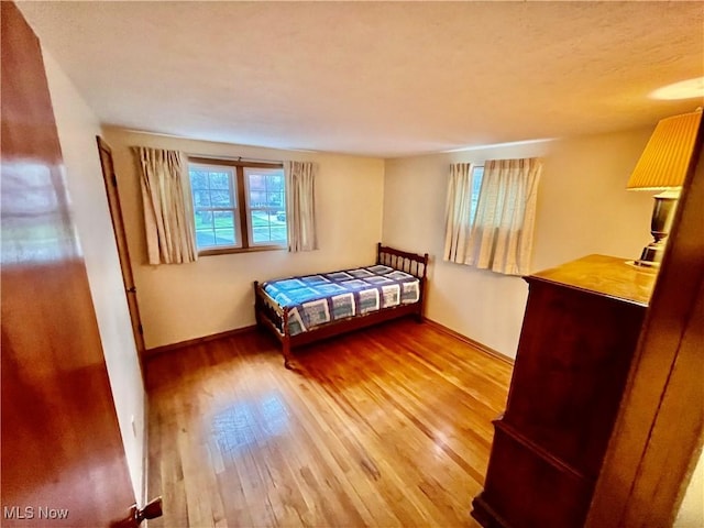 bedroom featuring baseboards and wood finished floors