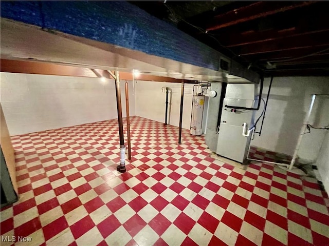 below grade area with gas water heater, tile patterned floors, and heating unit