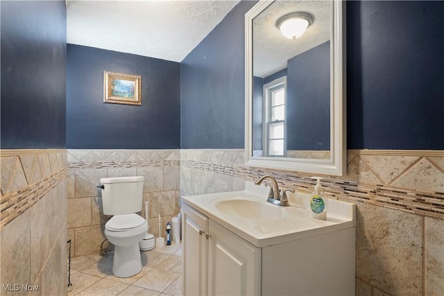 14221 S Woodland Rd, Shaker Heights, OH 44120 - half bathroom with tile walls, vanity, tile patterned floors, toilet, and wainscoting