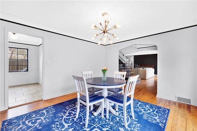 14221 S Woodland Rd, Shaker Heights, OH 44120 - dining room with an inviting chandelier, wood finished floors, visible vents, and arched walkways