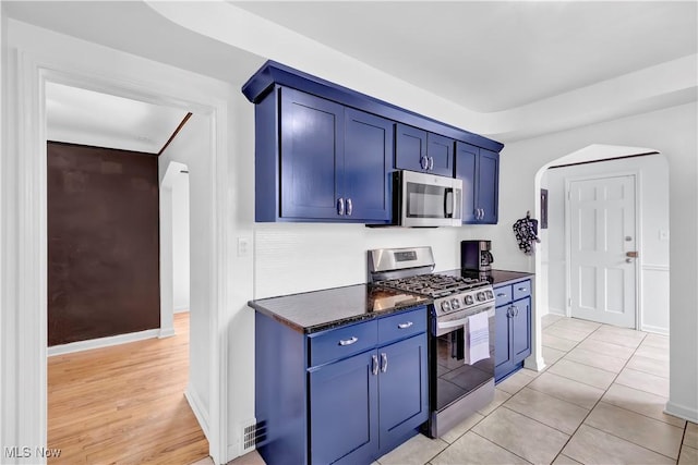 14221 S Woodland Rd, Shaker Heights, OH 44120 - kitchen featuring appliances with stainless steel finishes, blue cabinetry, baseboards, and arched walkways