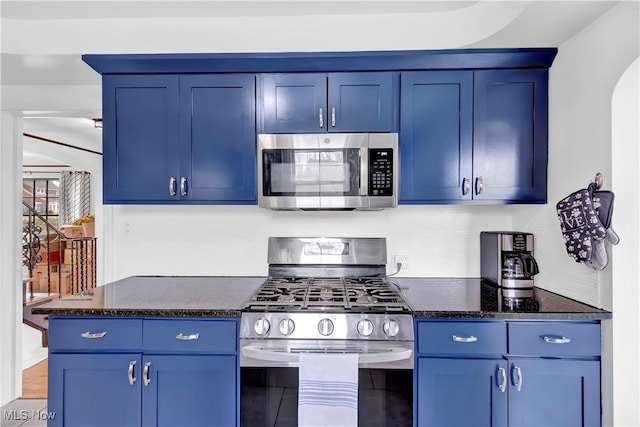 14221 S Woodland Rd, Shaker Heights, OH 44120 - kitchen with appliances with stainless steel finishes, decorative backsplash, dark stone countertops, arched walkways, and blue cabinets