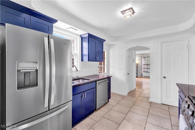 14221 S Woodland Rd, Shaker Heights, OH 44120 - kitchen with blue cabinets, arched walkways, dark countertops, and appliances with stainless steel finishes