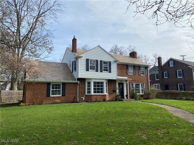 14221 S Woodland Rd, Shaker Heights, OH 44120 - view of front facade with fence, a chimney, a front yard, and brick siding