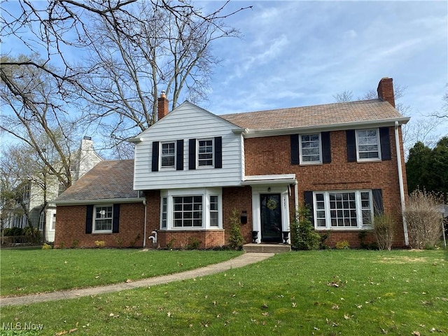 14221 S Woodland Rd, Shaker Heights, OH 44120 - view of front of home with a front yard, a chimney, and brick siding