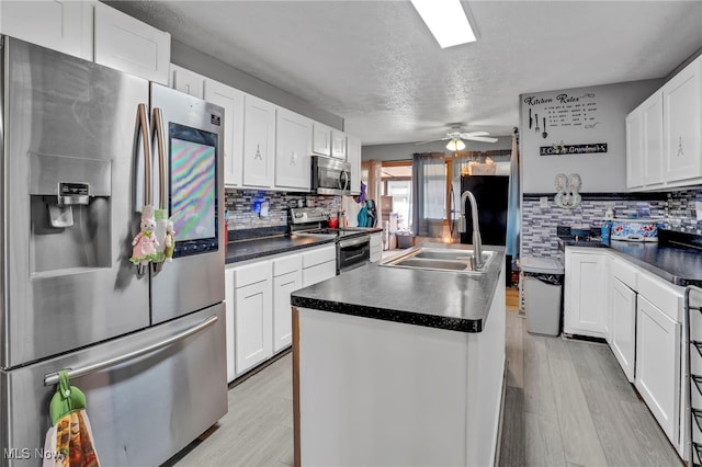 7687 Galena St NW, Massillon, OH 44646 - kitchen with appliances with stainless steel finishes, a sink, decorative backsplash, a textured ceiling, and dark countertops