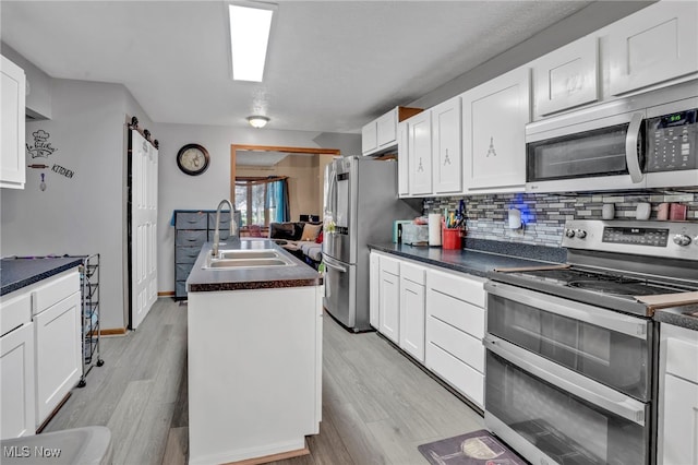 7687 Galena St NW, Massillon, OH 44646 - kitchen with appliances with stainless steel finishes, a sink, dark countertops, decorative backsplash, and white cabinets