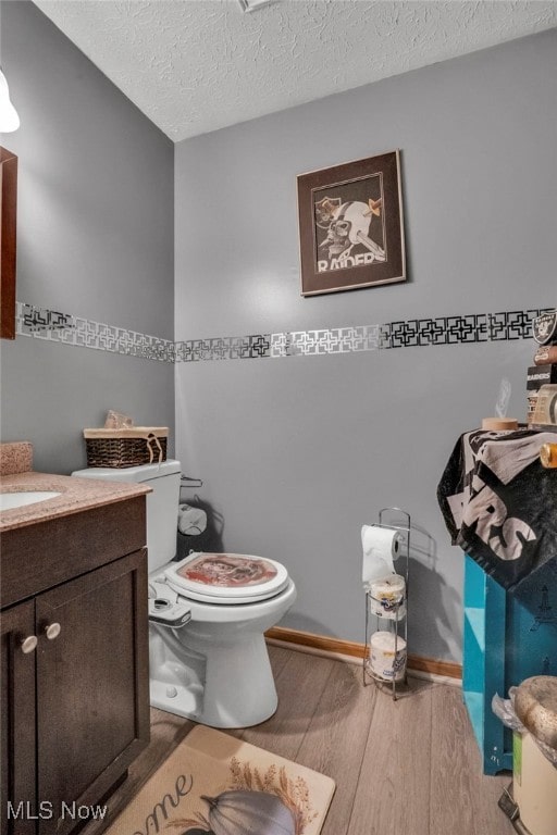 7687 Galena St NW, Massillon, OH 44646 - half bath with wood finished floors, toilet, a textured ceiling, vanity, and baseboards
