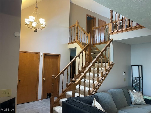 7687 Galena St NW, Massillon, OH 44646 - stairway featuring a high ceiling, a chandelier, and wood finished floors