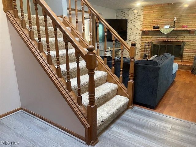 7687 Galena St NW, Massillon, OH 44646 - stairway with wood finished floors, baseboards, and a stone fireplace