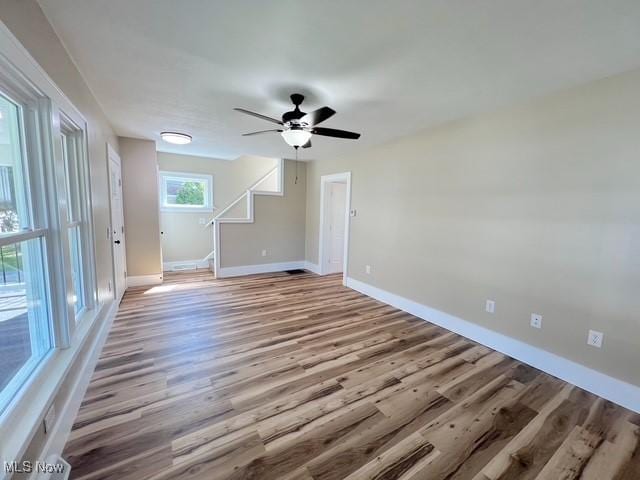 interior space with light wood-style flooring, baseboards, and ceiling fan