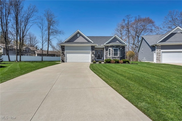 craftsman house with concrete driveway, a front lawn, fence, and stone siding